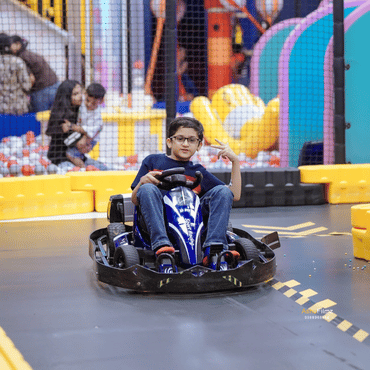 Boy enjoying a go-kart ride at Wooray Ludhiana kids play area